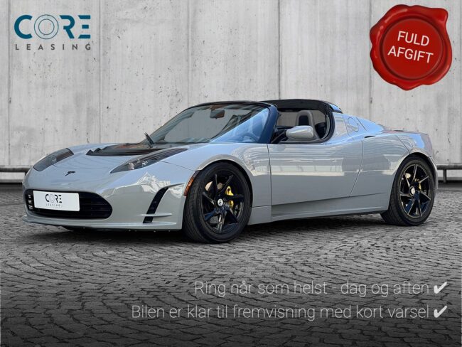 Gråmetal Tesla Roadster  fra 2010 parkeret foran en betonmur. CORE Leasing A/S er eksperter i Tesla leasing.