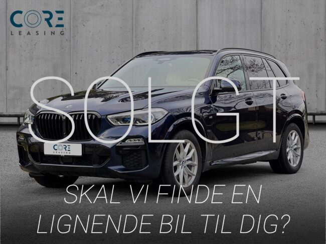 Blåmetal BMW X5 xDrive45e M-Sport aut. fra 2021 parkeret foran en betonmur. CORE Leasing A/S er eksperter i BMW leasing.