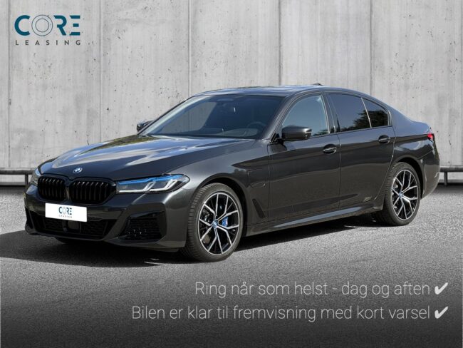 Gråmetal BMW 545e M-Sport xDrive aut. fra 2022 parkeret foran en betonmur. CORE Leasing A/S er eksperter i BMW leasing.