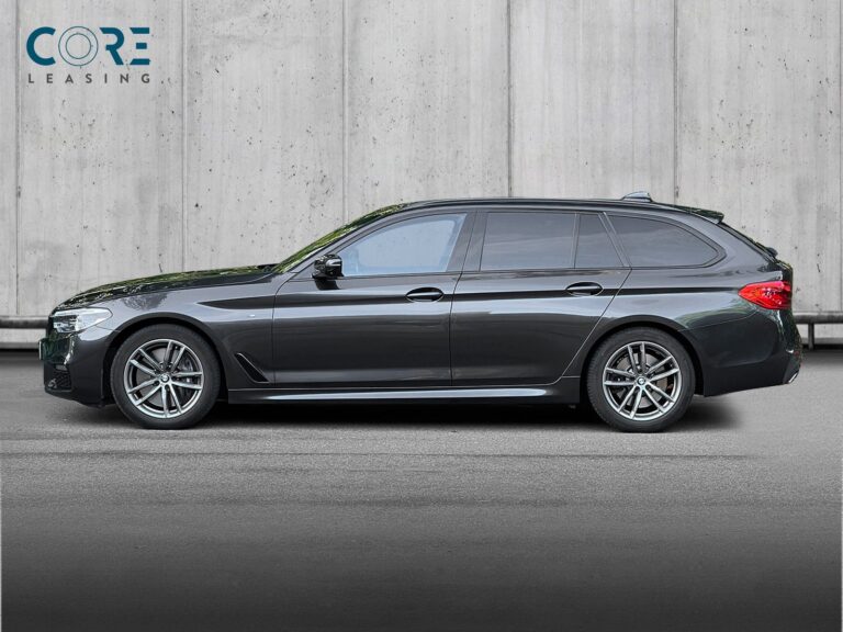 Gråmetal BMW 540i Touring M-Sport xDrive aut. fra 2019 parkeret foran en betonmur. CORE Leasing A/S er eksperter i BMW leasing.